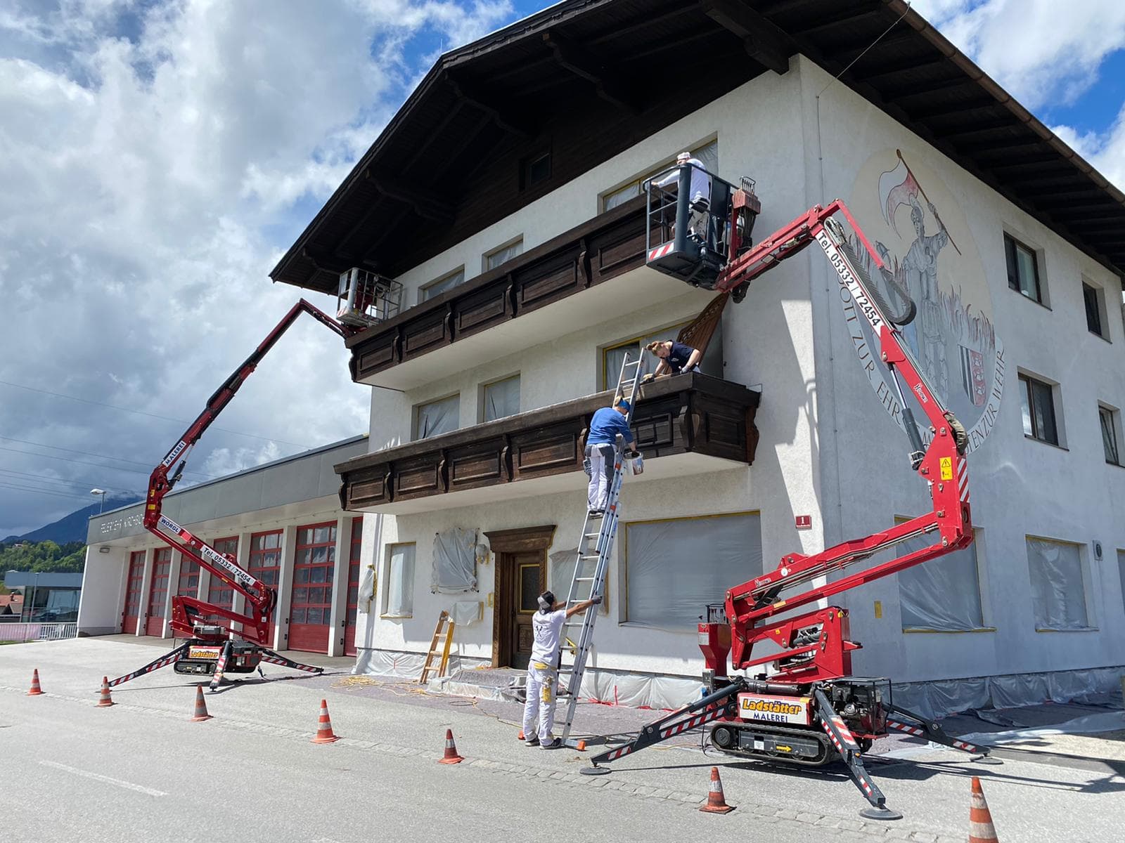 Fassadenmalerei am Feuerwehrhaus mit zwei Hebebühnen